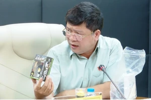 Ông Tạ Văn Hạ phân tích một mẫu thuốc lá điện tử nhập lậu, giả dạng đồ chơi trẻ em.