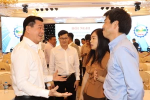 Bí thư Tỉnh ủy Đồng Nai Nguyễn Hồng Lĩnh (bên trái) trao đổi với doanh nghiệp tại một hội nghị. 