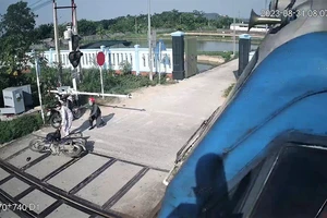 Nữ công nhân thông tin đường sắt Phạm Thị Hường cứu người thoát tai nạn tàu đâm trong gang tấc tại Diễn Châu (Nghệ An) vào sáng qua (Ảnh trích xuất camera giám sát đường ngang).