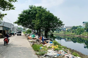 Rác thải của làng nghề làm chăn, ga, gối, đệm Trát Cầu (huyện Thường Tín, Hà Nội) đổ ra bờ sông Nhuệ.