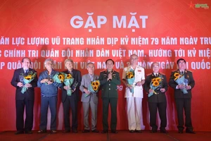 Thượng tướng Trịnh Văn Quyết trao biểu trưng và hoa tặng các nhà văn lực lượng vũ trang tiêu biểu. (Ảnh: Báo Quân đội nhân dân)