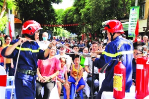 Người dân quận Tân Bình (TP Hồ Chí Minh) được các cán bộ, chiến sĩ phòng cháy, chữa cháy và cứu nạn, cứu hộ hướng dẫn cách thoát hiểm bằng dây thừng khi xảy ra cháy nổ. Ảnh | THẾ ANH