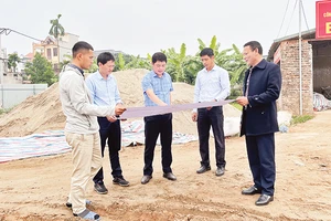 Cán bộ Trung tâm Phát triển quỹ đất huyện Mê Linh giới thiệu về quy hoạch chi tiết khu tái định cư Khê Ngoại 3, xã Văn Khê. (Ảnh HẢI CHI)