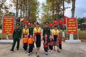 Cán bộ, chiến sĩ Đồn Biên phòng Keng Đu, huyện Kỳ Sơn (Nghệ An) với trẻ em dân tộc Khơ Mú.