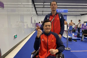 Kình ngư Lê Tiến Đạt (người ngồi) xuất sắc giành tấm Huy chương vàng duy nhất cho Đoàn thể thao Người khuyết tật Việt Nam ở nội dung 100m bơi ếch.