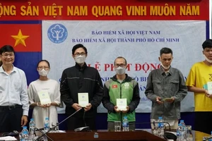 Trao thẻ bảo hiểm y tế, sổ bảo hiểm xã hội cho người dân có hoàn cảnh khó khăn, diện chính sách trên địa bàn Thành phố Hồ Chí Minh. (Ảnh: HSS)