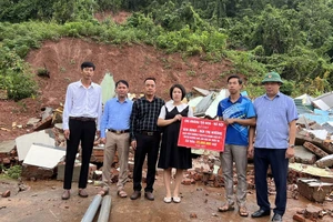 Đại diện Báo Giáo dục và thời đại cũng lãnh đạo huyện Mường Nhé trao tiền hỗ trợ gia đình cô giáo Bùi Thị Hương.