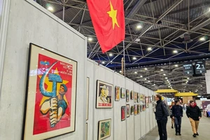 Những bức tranh vẽ cổ động phong trào thi đua yêu nước của Việt Nam thu hút sự chú ý của khách tham quan. (Ảnh: MINH DUY)