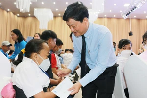 Chủ tịch Ủy ban nhân dân tỉnh Bình Dương Võ Văn Minh trao quà tặng cho công nhân khó khăn, công nhân bị bệnh hiểm nghèo. 