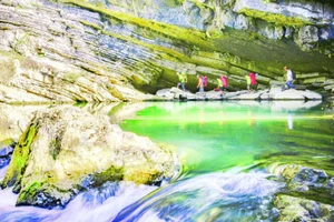 Khách du lịch khám phá hang động Tú Làn ở huyện Minh Hóa (Quảng Bình). 