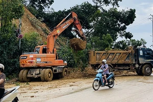 Sử dụng gầu xúc hốt đất, đá do sạt lở núi trên đường Bách Lẫm, thành phố Yên Bái, tỉnh Yên Bái.