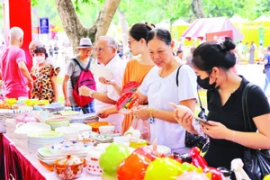 Khách du lịch tìm hiểu sản phẩm tại Lễ hội Quà tặng du lịch Hà Nội mới được tổ chức.