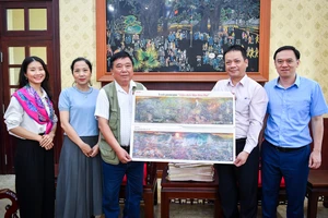 Đồng chí Phạm Song Hà, Ủy viên Ban Biên tập, Trưởng Ban Chính trị - Xã hội tặng phụ san cho trưởng nhóm tác giả.