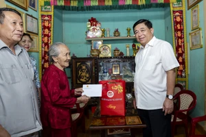 Bộ trưởng Kế hoạch và Đầu tư Nguyễn Chí Dũng (phải) thăm, tặng quà Mẹ Việt Nam Anh hùng Tạ Thị Phún ở huyện Vĩnh Linh, tỉnh Quảng Trị. (Ảnh: MINH SƠN)