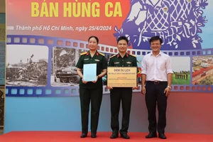 Đại tá Nguyễn Ngọc Điệp (trái), Giám đốc Bảo tàng Lực lượng vũ trang miền Đông Nam bộ nhận quyết định công nhận điểm du lịch của Sở Du lịch Thành phố Hồ Chí Minh.
