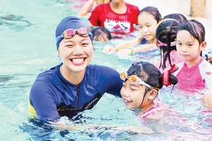 Ánh Viên hỗ trợ dạy bơi miễn phí cho các em nhỏ trong chương trình phòng chống đuối nước. Ảnh: Minh Tân 