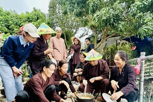 Khách du lịch trải nghiệm nấu bánh đúc khi đến với mô hình du lịch nông nghiệp tại Giang Biên (quận Long Biên, Hà Nội).
