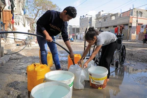 Người dân ở phía nam Dải Gaza lấy nước phục vụ sinh hoạt. (Ảnh TÂN HOA XÃ) 