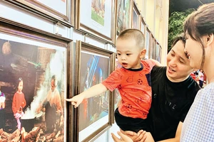 Gia đình trẻ tham quan trưng bày ảnh “Nét đẹp trong văn hóa các gia đình Việt Nam”.