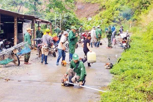 Cán bộ, chiến sĩ Đồn Biên phòng Ia Dom cùng người dân phát quang bụi rậm khu vực đường biên, cột mốc. 