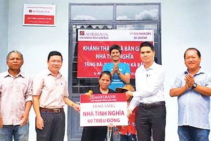 Đại diện Báo Nhân Dân và Ngân hàng Agribank cùng đại diện xã Sa Bình trao nhà tình nghĩa cho gia đình chị Y Ung (thôn Kà Bầy, xã Sa Bình, huyện Sa Thầy).