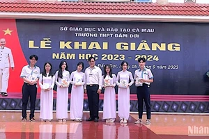 Hiệu trưởng Trường Trung học phổ thông Đầm Dơi (Cà Mau) trao tặng tập học sinh vận động từ Báo Nhân dân cho học sinh vượt khó học giỏi tại địa phương. 