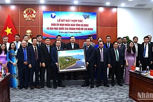 Lãnh đạo tỉnh Cà Mau tặng quà và chụp ảnh lưu niệm với đại diện Đại học Quốc gia Thành phố Hồ Chí Minh tại lễ ký kết.