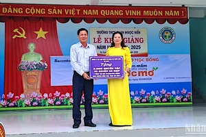 Đại diện chính quyền địa phương và đơn vị trường học tại huyện Đầm Dơi tiếp nhận hỗ trợ xe đạp và tập học sinh được vận động từ Báo Nhân Dân.