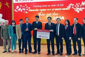 Giám đốc chi nhánh Agribank Bắc Yên Bái trao biểu trưng 500 triệu đồng cho người nghèo tỉnh Yên Bái. (Ảnh: THANH SƠN)