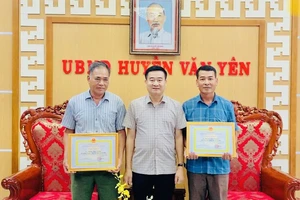 Đại diện Ủy ban nhân dân huyện Văn Yên khen thưởng 2 công dân dũng cảm cứu trẻ em khỏi đuối nước. (Ảnh: THANH SƠN)