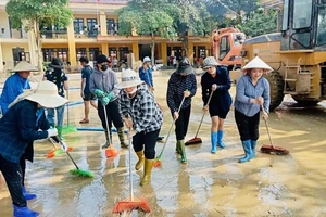 Giáo viên cùng các phụ huynh học sinh trường Minh Chuẩn, huyện Lục Yên vệ sinh sân trường sau bão số 3. (Ảnh: THANH SƠN)