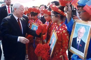 Tổng Bí thư Nguyễn Phú Trọng hỏi thăm các cháu thiếu nhi là con em người gốc Việt Nam tại Campuchia. (Ảnh: Hội Khmer-Việt Nam cung cấp)