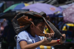 Học sinh đến trường dưới trời nắng gay gắt tại Manila, Philippines ngày 2/4/2024. Ảnh: AFP/TTXVN