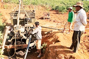 Người dân xã Ia Sao, huyện Ia Grai lắp đặt máy bơm để tưới nước cho cây cà-phê. 