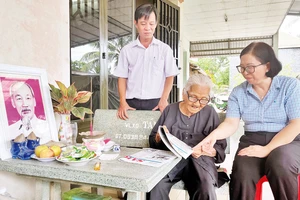 Bí thư Đảng ủy thị trấn Tân Túc Trần Thị Hải Yến (phải) và Bí thư Chi bộ Khu phố 9 Phạm Quang Vũ thăm hỏi đồng chí Nguyễn Thị Mười.