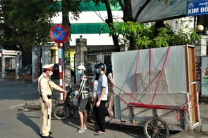 Cảnh sát giao thông kiểm tra, xử lý xe tự chế chở hàng cồng kềnh gây mất an toàn giao thông tại khu vực phố Kim Đồng (quận Hoàng Mai, Hà Nội).