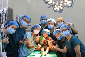 Một kíp phẫu thuật nụ cười của Bệnh viện Việt Nam-Cuba (Hà Nội) cùng bệnh nhi. (Ảnh: MICHEL NGUYỄN)