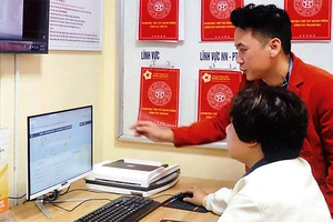 Cán bộ phường Quỳnh Lôi (quận Hai Bà Trưng) hướng dẫn người dân thực hiện dịch vụ công trực tuyến. (Ảnh: LINH NGUYỄN )