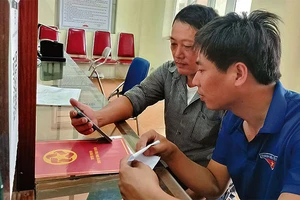 Đoàn viên thanh niên xã Minh Tân (huyện Phú Xuyên) hướng dẫn người dân thực hiện thủ tục hành chính online.
