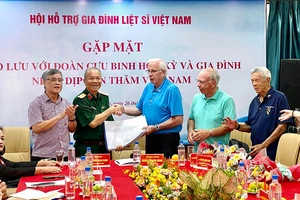 Cựu chiến binh Mỹ Bob Connor (thứ 3 từ trái sang) trao hồ sơ thông tin mộ liệt sĩ cho Trung tướng Hoàng Khánh Hưng, Chủ tịch Hội Hỗ trợ gia đình liệt sĩ Việt Nam.