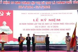 Thừa ủy nhiệm, Chủ tịch Ủy ban nhân dân tỉnh Bình Dương Võ Văn Minh (thứ 2 từ trái sang) trao Huân chương Lao động hạng Nhất cho lãnh đạo thành phố Tân Uyên. 