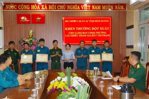 Thượng tá Đặng Xuân Thành trao Giấy khen cho các chiến sĩ dân quân.