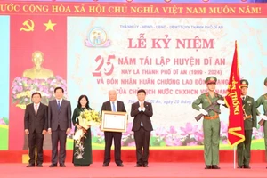 Thừa ủy nhiệm, Chủ tịch Ủy ban nhân dân tỉnh Bình Dương Võ Văn Minh trao Huân chương Lao động hạng Nhất cho Đảng bộ, chính quyền và nhân dân thành phố Dĩ An.