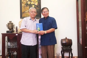 PGS, TS Nguyễn Ngọc Thiện (bên trái) tặng cuốn sách - Khúc hợp đàn văn - cho nhà thơ Lê Tuấn Lộc - tác giả bài viết.