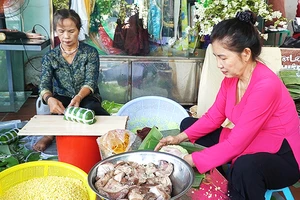 Bà Bùi Thị Bên (bên phải) duy trì việc gói bánh tét tặng người nghèo từ nhiều năm nay.