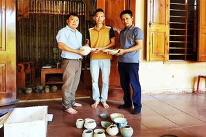Việt Anh (giữa) hiến tặng cổ vật cho Bảo tàng Tổng hợp tỉnh Quảng Bình.