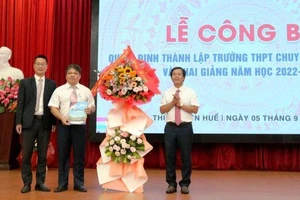 Chủ tịch UBND tỉnh Thừa Thiên Huế Nguyễn Văn Phương trao quyết định và tặng hoa chúc mừng nhà trường. (Ảnh: Trường đại học Khoa học cung cấp)