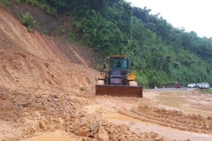 Tập trung san gạt đất lở tại dốc Chó, xã Lạng Khê (Con Cuông) để thông xe trên quốc lộ 7 kịp thời.