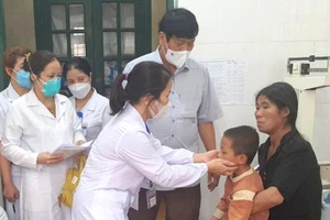Bác sĩ Trung tâm Kiểm soát bệnh tật Bắc Kạn khám cho bệnh nhi nghi nhiễm cúm B tại Chợ Đồn. (Ảnh: CDC Bắc Kạn)