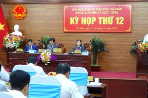 Chủ tịch Ủy ban nhân dân tỉnh Cà Mau Huỳnh Quốc Việt (bìa phải) trình bày báo cáo về tình hình phát triển kinh tế-xã hội năm 2023 và phương hướng, nhiệm vụ năm 2024.